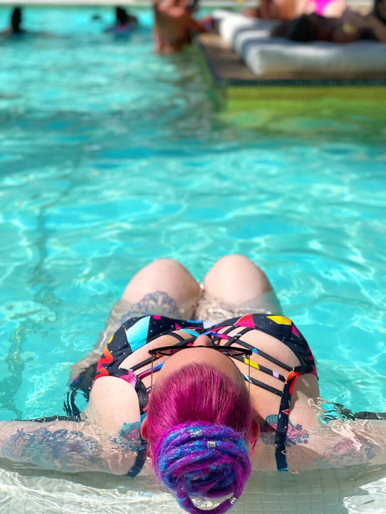 roxy tart laying in a pool in the sun
